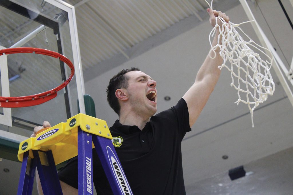 Basketball player cheering after cutting down the net