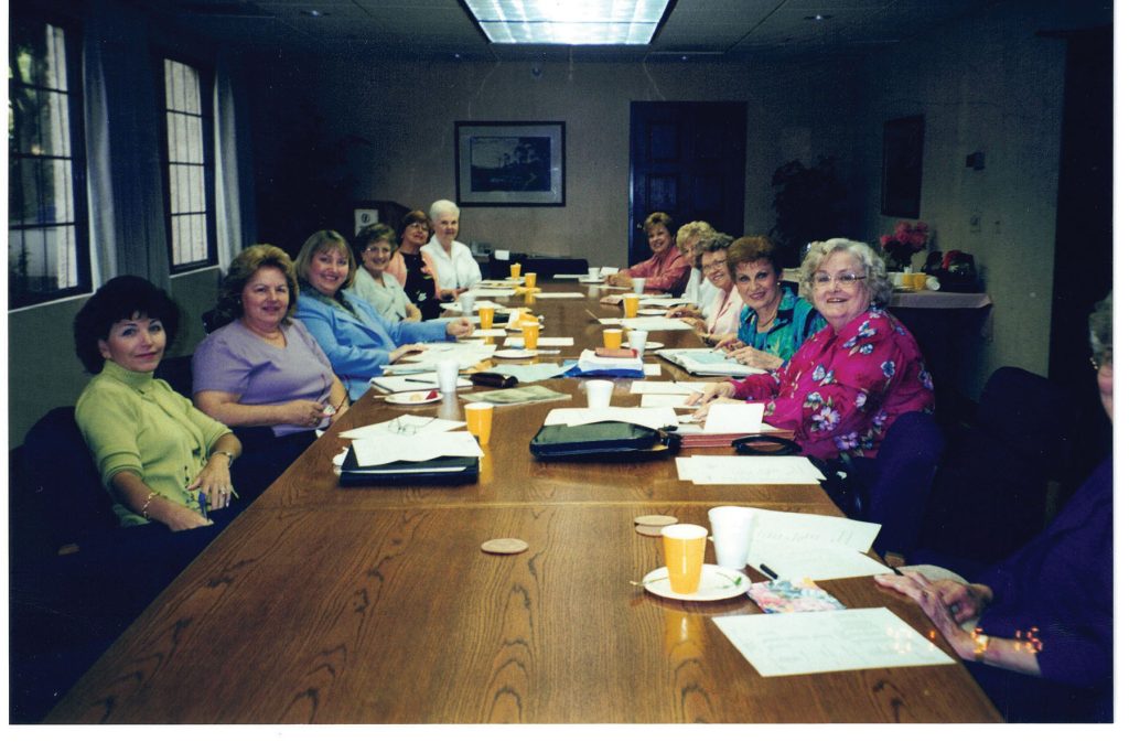 The Women's Auxiliary circa 2001 seated around a table. 