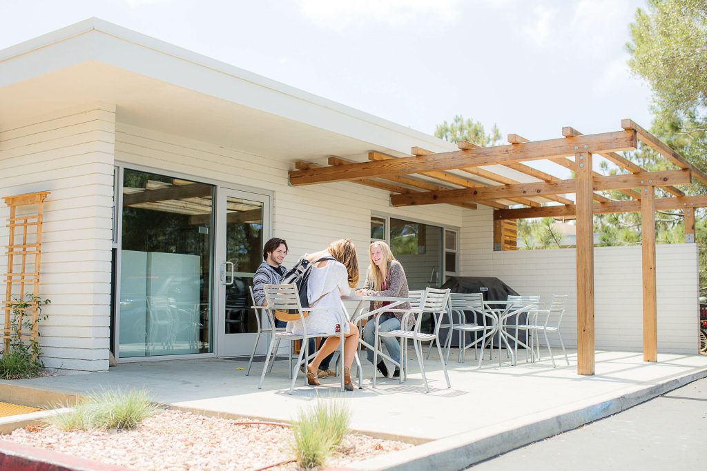 Students sitting at a table on the Nease patio. 