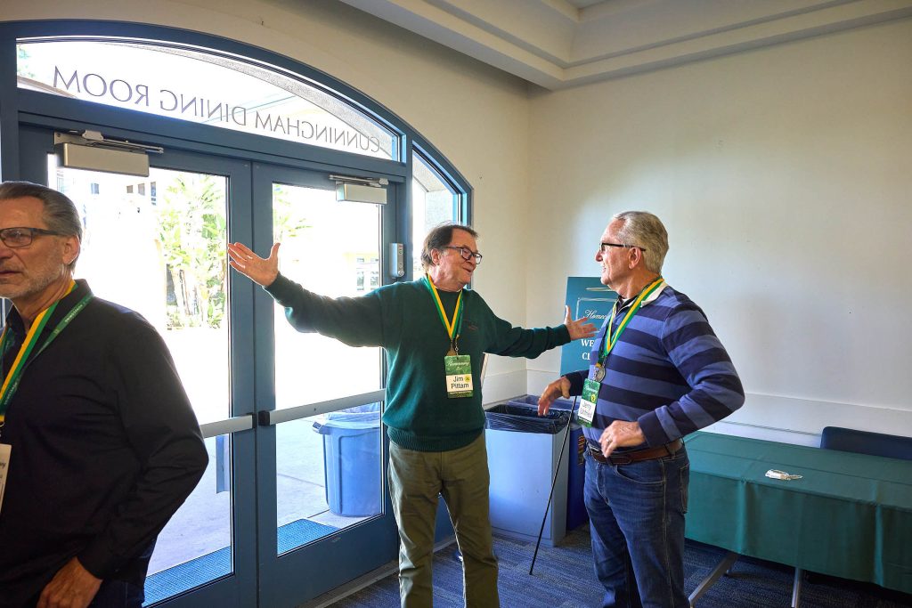 Two PLNU alums greet each other warmly and swap memories.