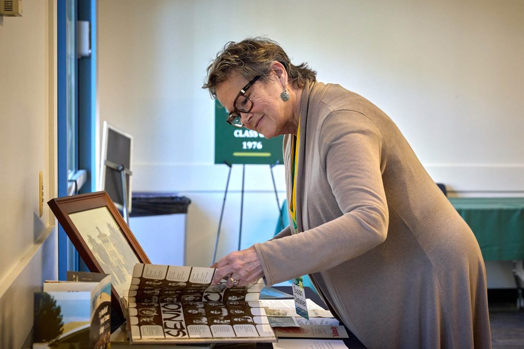A PLNU alumna looks through yearbook photos