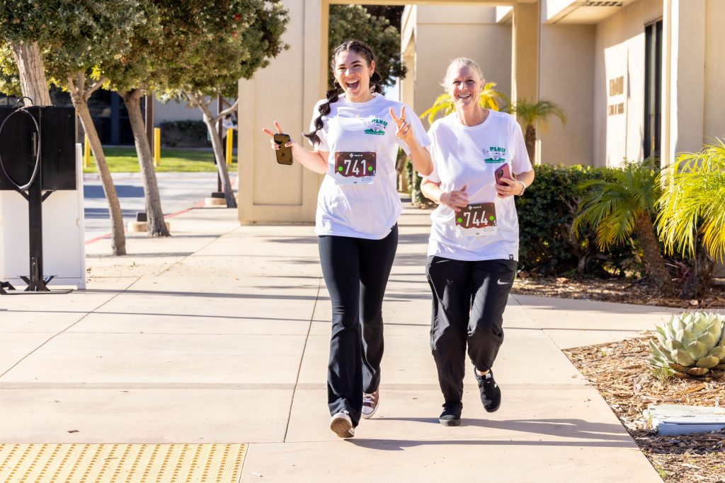 A mother in daughter smile as they run in the PLNU Homecoming 5K.