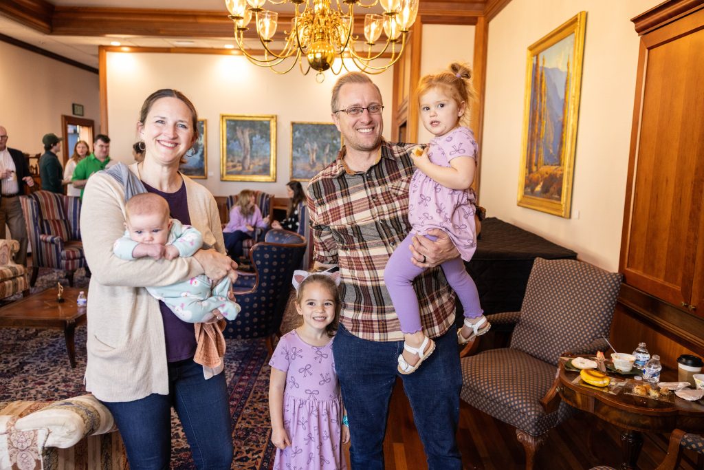 A family with their 3 young children smile during Homecoming weekend celebrations.