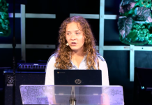 Rianna Nowlin Carves Her Own Path by Leading With Compassion a young woman speaks in the center of the stage